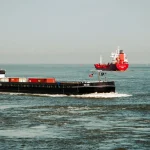Контейнеровози в морі під ясним небом, що демонструє морський транспорт.
