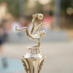 Золотий футбольний трофей зі стрічками на підставці
