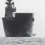 Могутній авіаносець рухається відкритим морем, демонструючи свої гігантські розміри та силу.