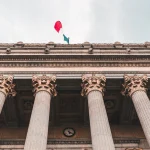 Класичні колони та французський прапор на даху будівлі з архітектурою у стилі класицизм.