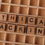 Дерев'яні блоки, що складаються у слова 'ethical hacking', символізуючи концепції кібербезпеки.