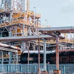 Нафтопереробний завод з танкерами під ясним небом.