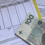 Банкнота номіналом 100 злотих лежить на фінансових документах і рахунках на столі