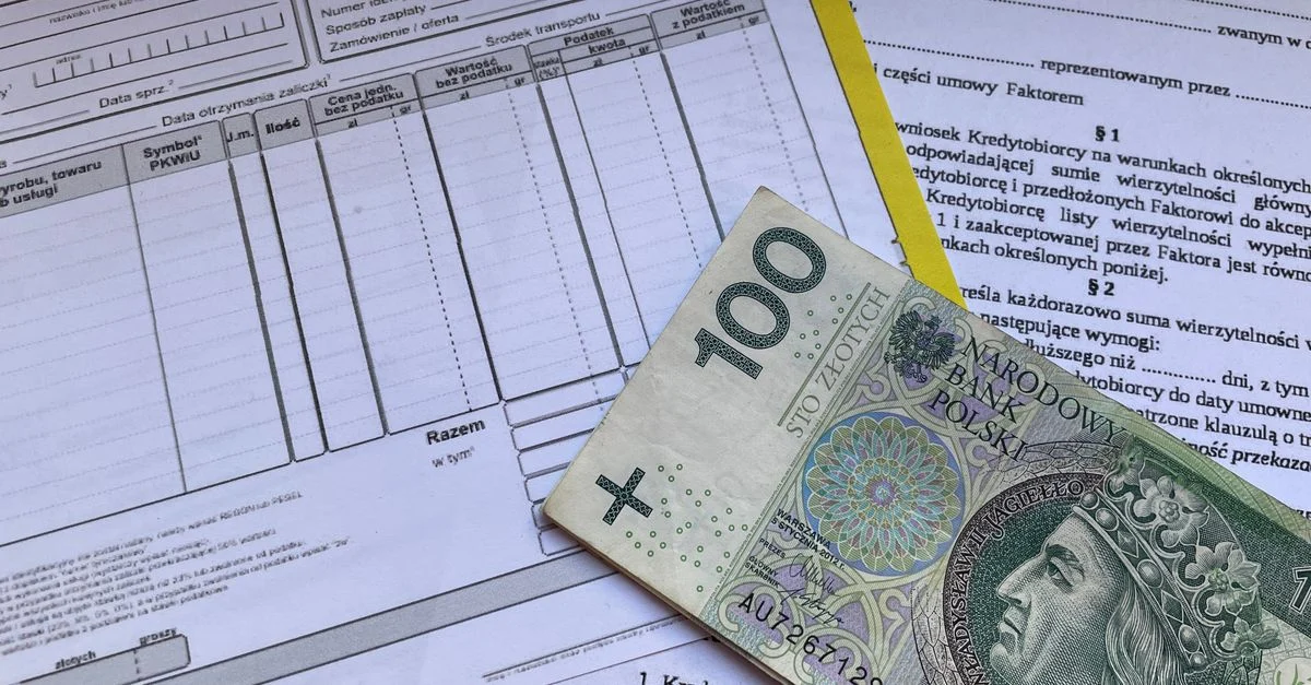 Банкнота номіналом 100 злотих лежить на фінансових документах і рахунках на столі