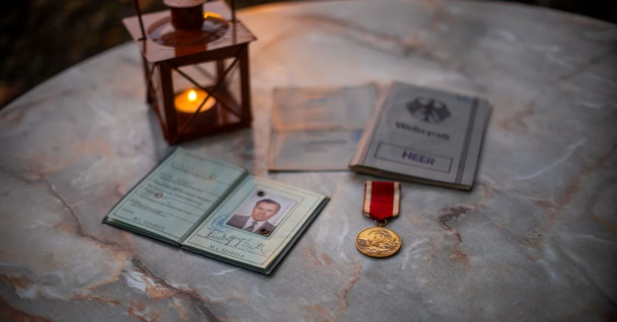 Вінтажні військові речі та ліхтар, що світиться, на кам’яному столі.