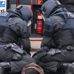 Поліцейські у повному спорядженні затримують підозрюваного на міській вулиці