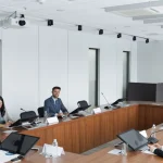 Міжнародна група фахівців проводить ділову зустріч у сучасній конференц-залі.